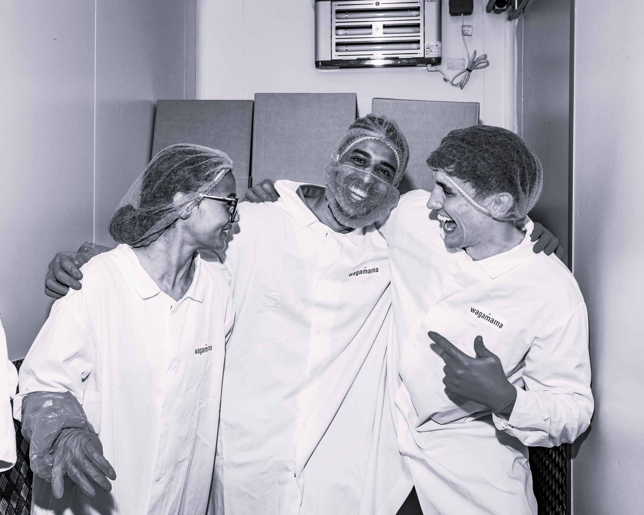 Three smiling people in lab coats with "wagamama" on them.