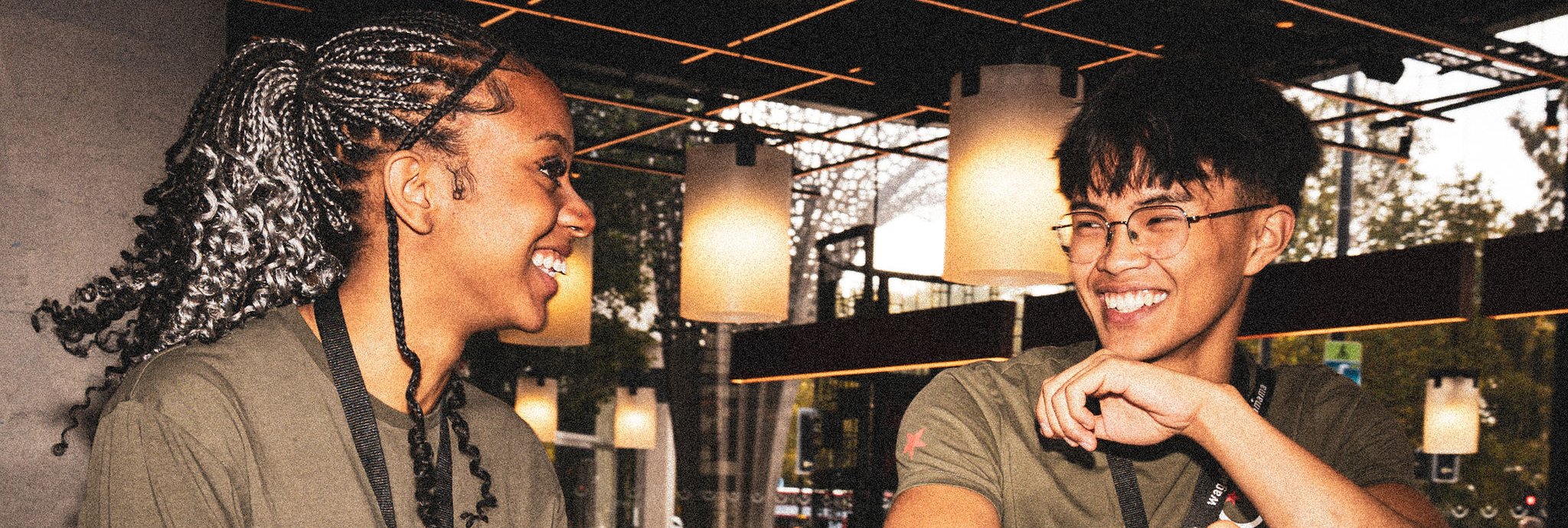 Two people smiling, looking at each other over a bar.