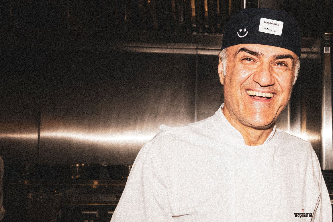 Chef in a kitchen setting with oven behind him.