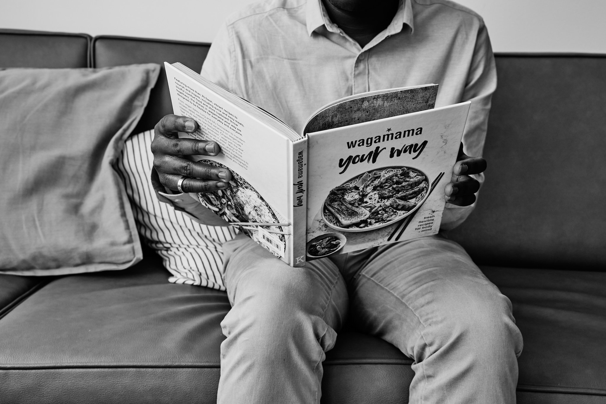 Person reading the "wagamama your way" cookbook.