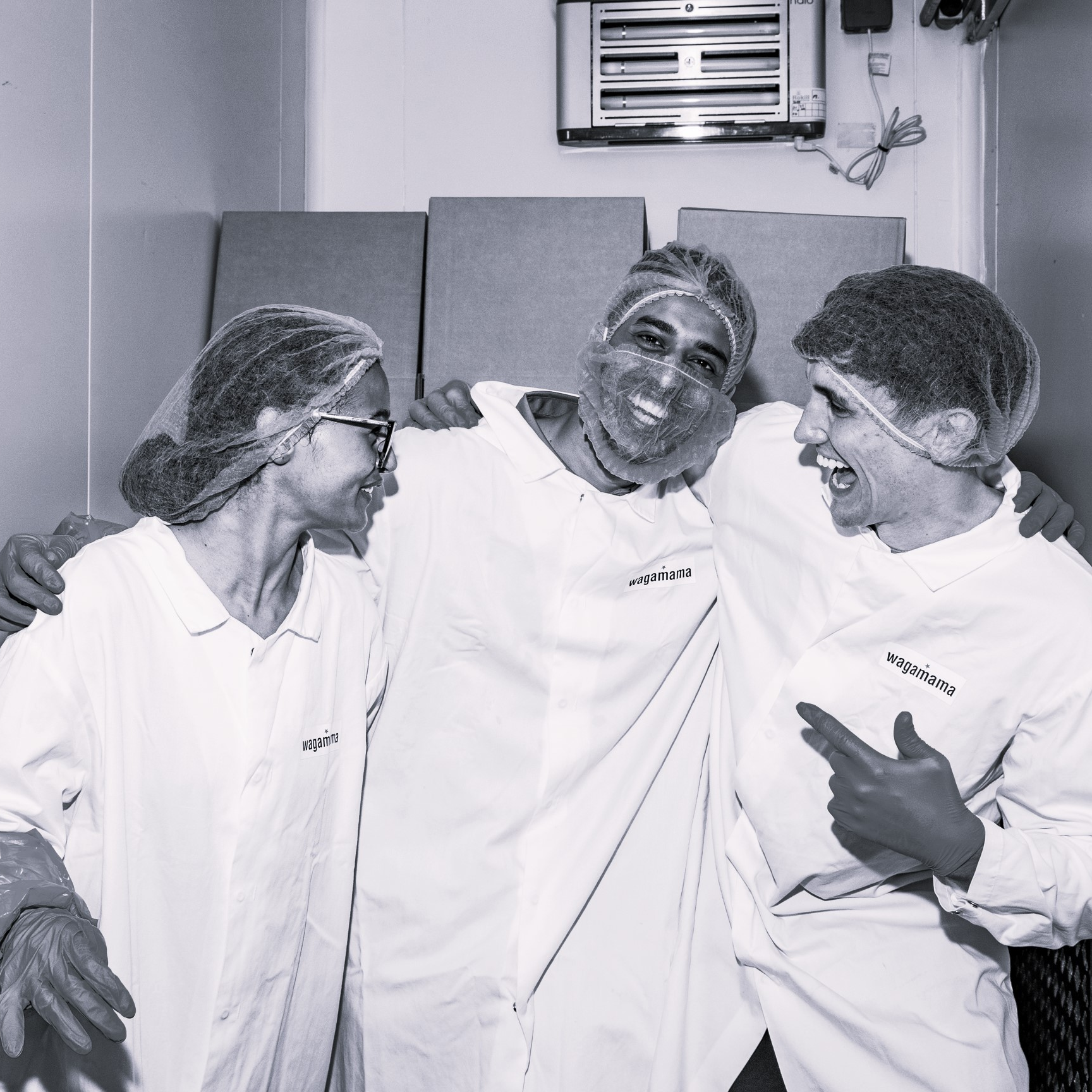 Three people in uniform, laughing together.