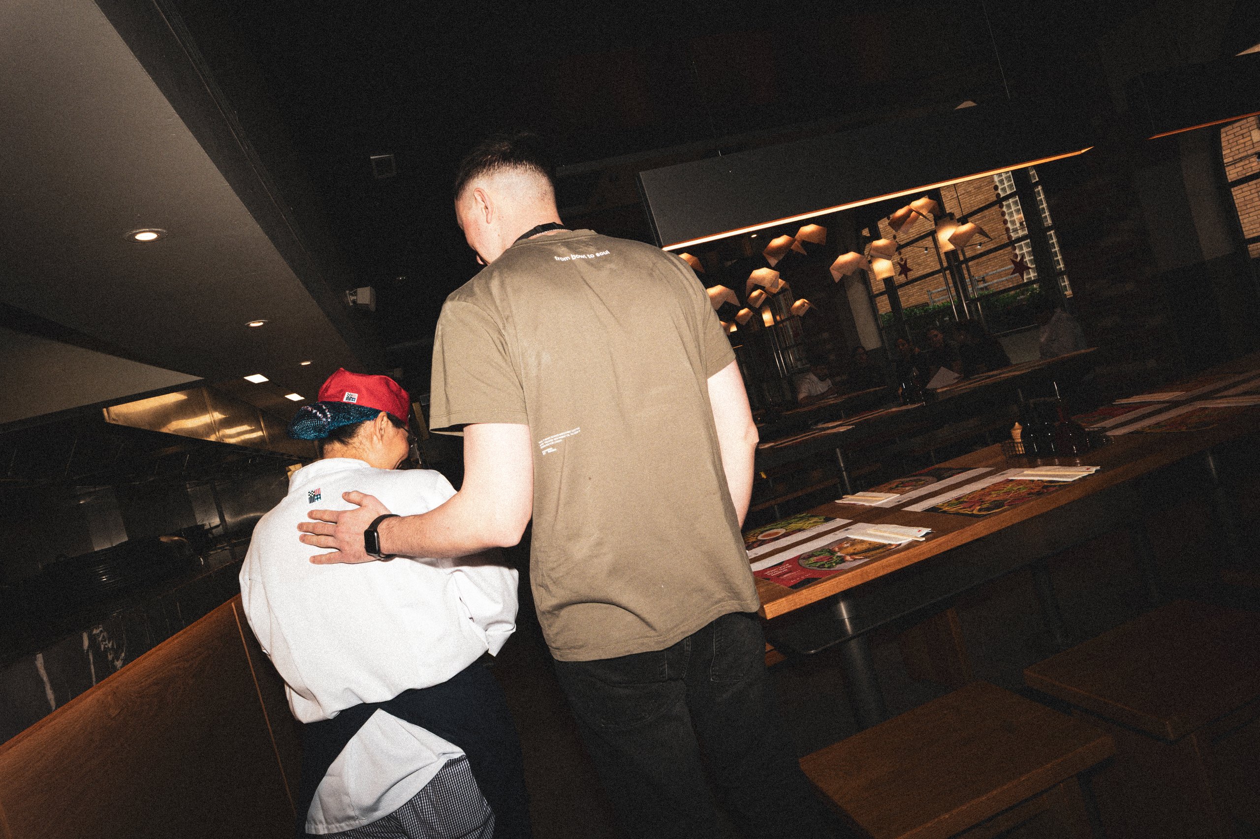 Two people, one in a chef's uniform, at a table.