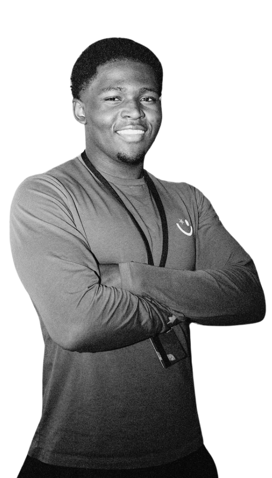 A smiling young Black man with arms crossed, isolated against a white background.